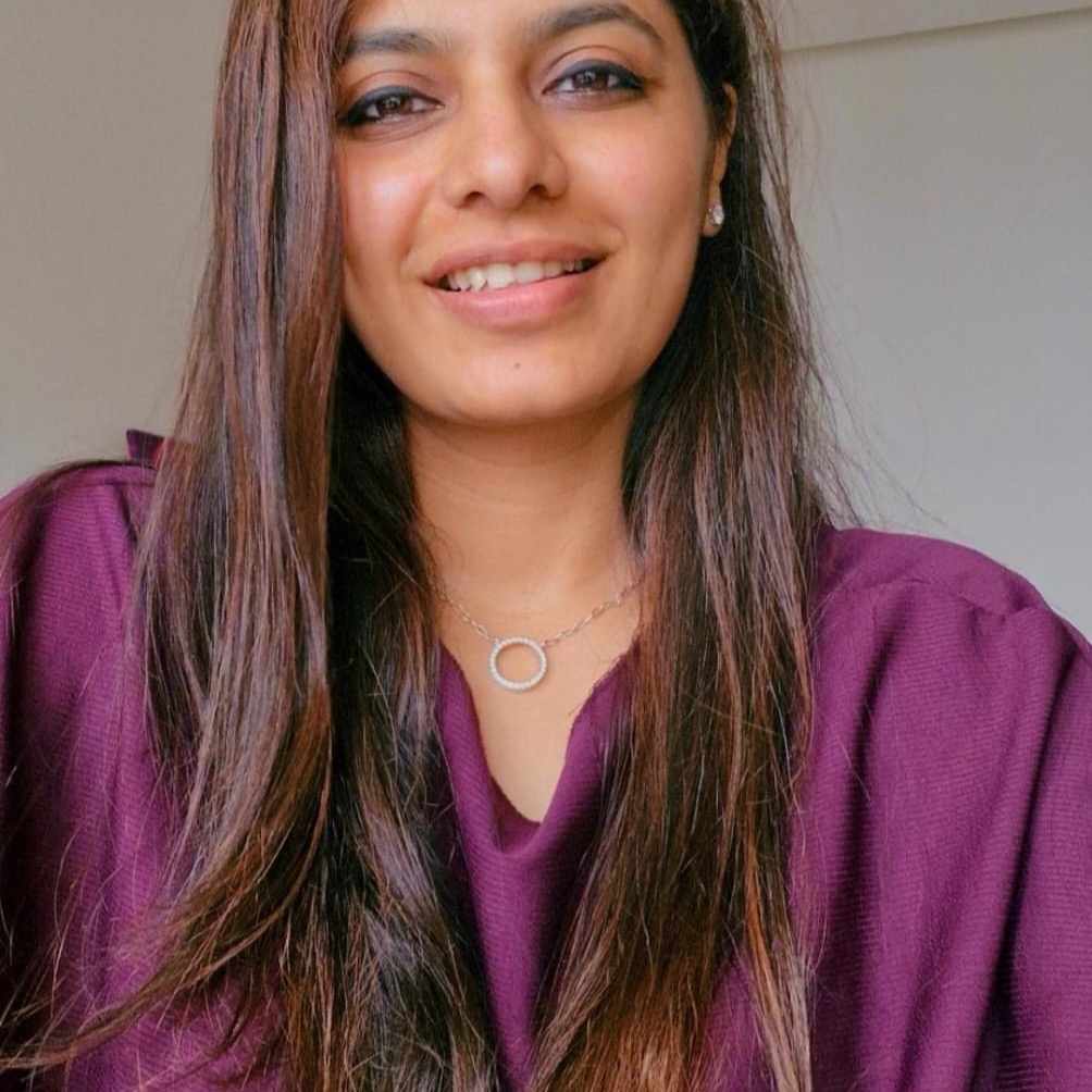 Photo of Nidhi Shah, smiling, with long dark hair